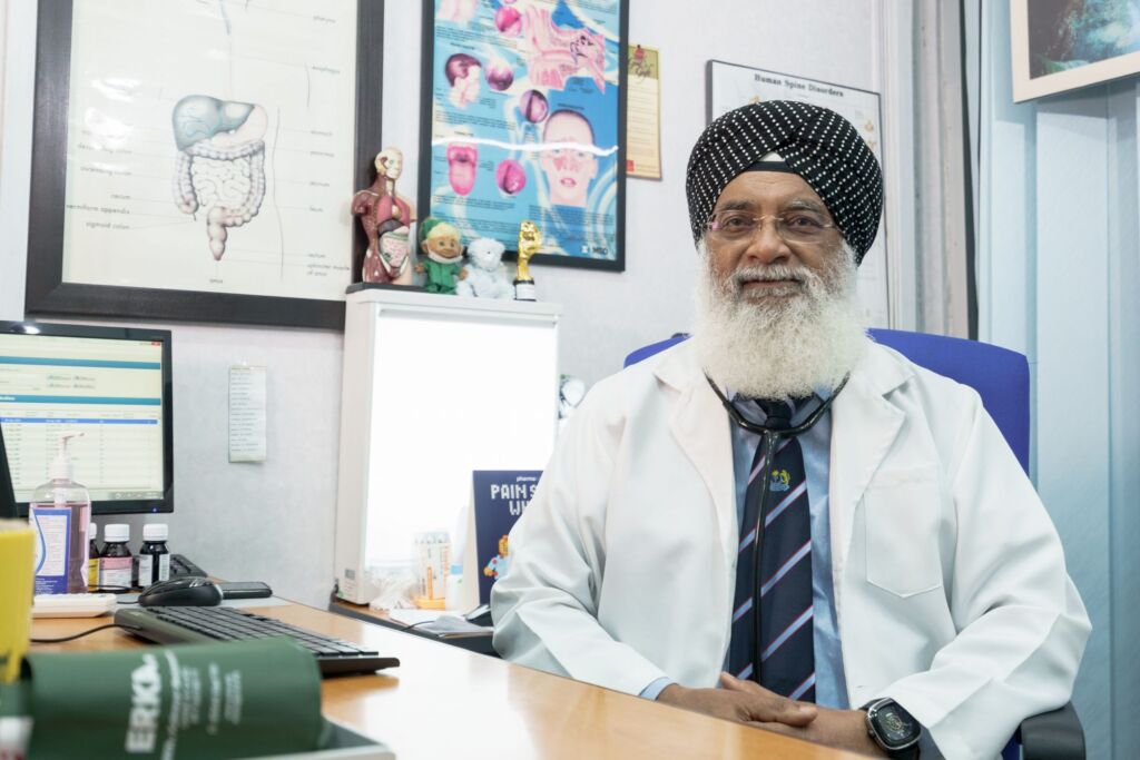 Dr Bhagwan seated in a KNS consultation room